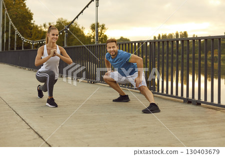 Couple in sportswear doing stretching on a bridge, close-up Couple in sportswear doing stretching on a bridge, close-up 130403679