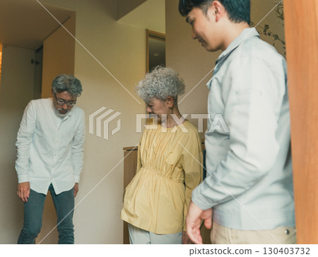 An elderly couple and a contractor in the entrance hall 130403732
