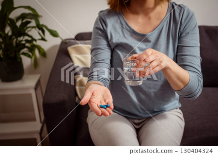 Woman holding blue pills in hand. Health care, dietary supplements, treatment of depression and diseases Woman holding blue pills in hand. Health care, dietary supplements, treatment of depression and diseases 130404324
