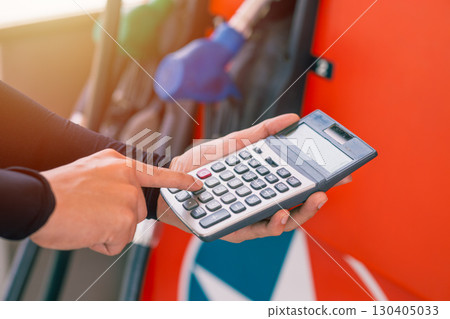 Closeup gas station staff worker hand calculator calculate price car fuel cost, Petroleum business 130405033