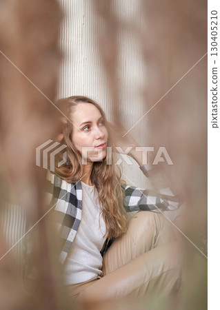Caucasian young female sitting in thoughtful pose with plaid shirt and long Caucasian young female sitting in thoughtful pose with plaid shirt and long 130405210
