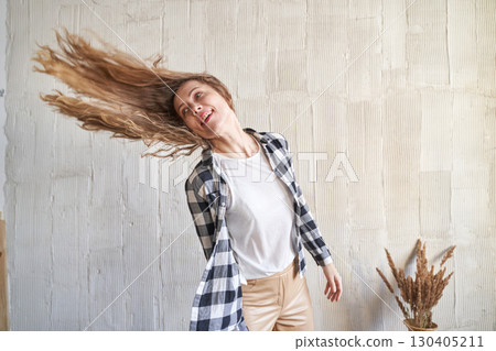 Happy caucasian young female tossing long hair in casual outfit with checkered Happy caucasian young female tossing long hair in casual outfit with checkered 130405211