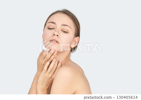 Young caucasian female with subtle makeup and bare shoulders expressing Young caucasian female with subtle makeup and bare shoulders expressing 130405614