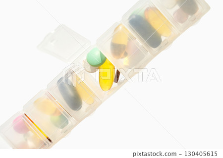 Daily pill organizer with various colorful tablets and supplements for health 130405615