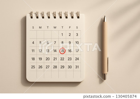 Spiral desk calendar with red circle on 15th date and beige pen on neutral background, deadline or appointment reminder concept 130405874