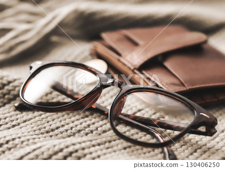Stylish Eyeglasses and a Chic Wallet on Soft, Cozy Textiles for a Fashionable Look 130406250