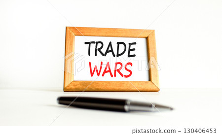 Trade wars symbol. Concept word Trade wars on beautiful wooden picture frame. Black pen. Beautiful white paper background. Business trade wars concept. Copy space. Trade wars symbol. Concept word Trade wars on beautiful wooden picture frame. Black pen. Beautiful white paper background. Business trade wars concept. Copy space. 130406453