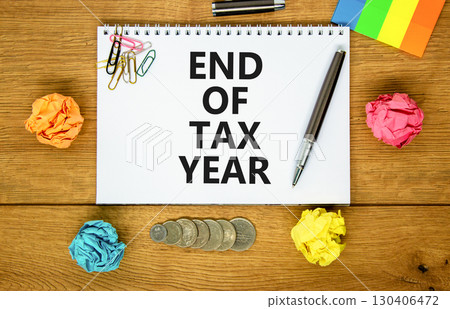 End of tax year symbol. Concept words phrase End of tax year on beautiful white note. Colored paper. Beautiful wooden background. Business End of tax year concept. Copy space. 130406472