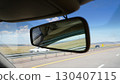 Rear view mirror reflecting car passing on highway road 130407115