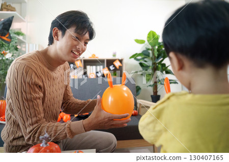 Halloween Family Joy. Father and son bonding over Halloween decorations and playful activities. 130407165