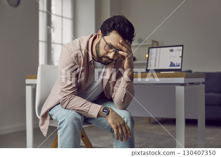 Stressed, tired, frustrated young business man is experiencing a burnout at work 130407350