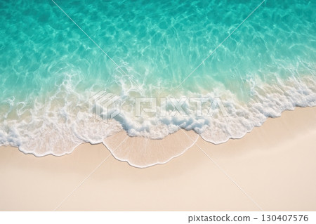Turquoise waves gently lap against a golden sandy shore under bright sunlight on a serene beach 130407576