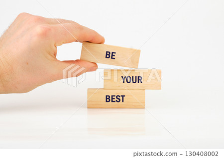Business motivational concept. Copy space. Words BE YOUR BEST made from blocks with hand on white background Business motivational concept. Copy space. Words BE YOUR BEST made from blocks with hand on white background 130408002