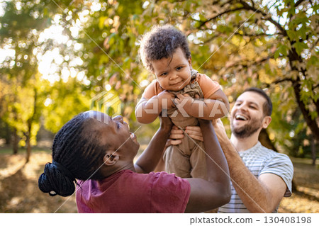 Joyful family playtime in a sunlit park during autumn days Joyful family playtime in a sunlit park during autumn days 130408198