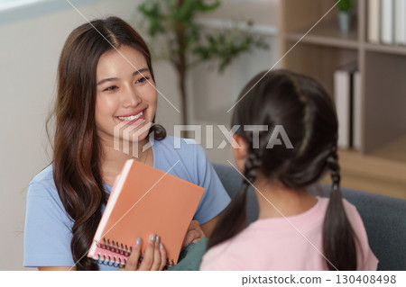 Child and Education. A joyful interaction between a mother and daughter preparing for school. Child and Education. A joyful interaction between a mother and daughter preparing for school. 130408498