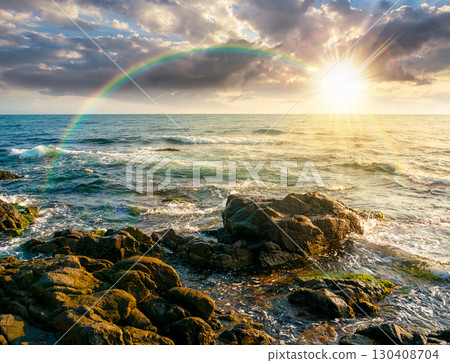 sea coast with rocks and boulders at sunset. calm summer vacation background at the seashore. wonderful scene for relax and leisure at the seaside in evening light 130408704