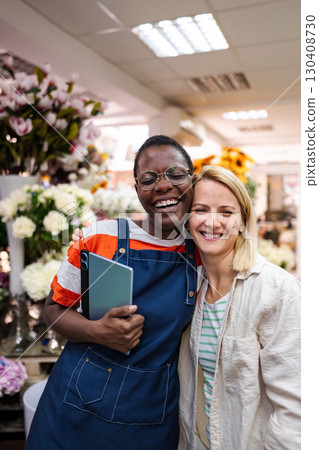 Two happy female florists embracing in a flower shop Two happy female florists embracing in a flower shop 130408730