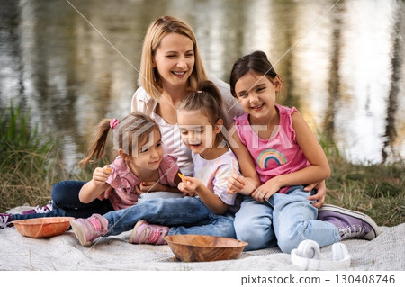 Happy family enjoying a picnic by the lake 130408746