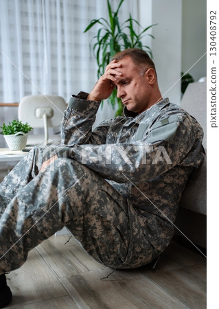 Depressed soldier sitting on the floor suffering from post-traumatic stress disorder Depressed soldier sitting on the floor suffering from post-traumatic stress disorder 130408792