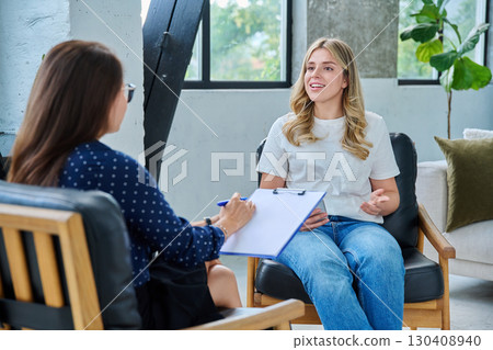 Smiling happy young woman at session with psychologist, therapist 130408940