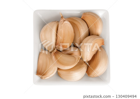 garlic cloves in ceramic bowl isolated on white background close up. Top view. Flat lay. 130409494