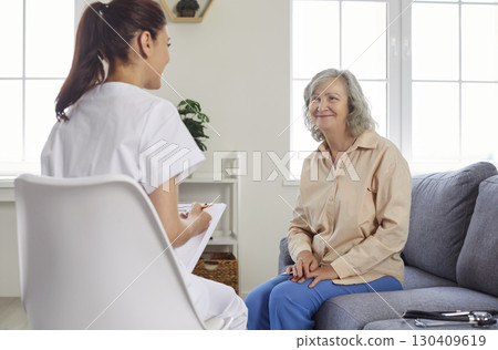 Young physician or nurse is talking to senior woman patient during her home visit Young physician or nurse is talking to senior woman patient during her home visit 130409619