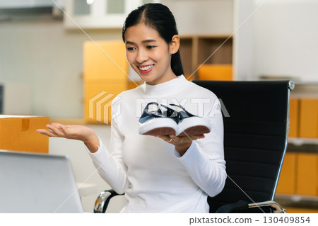 Asia vlogger woman influencer, SME retail store owner smile enjoy selling show live sale online screen smartphone and laptop work at home. Asia vlogger woman influencer, SME retail store owner smile enjoy selling show live sale online screen smartphone and laptop work at home. 130409854