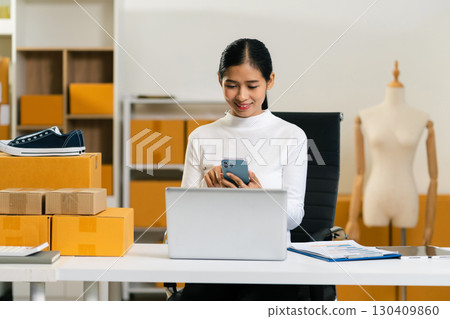 Woman holding smart phones. Entrepreneur working at home. Online shopping, e-commerce, internet banking, spending money, working from home concept. Woman holding smart phones. Entrepreneur working at home. Online shopping, e-commerce, internet banking, spending money, working from home concept. 130409860