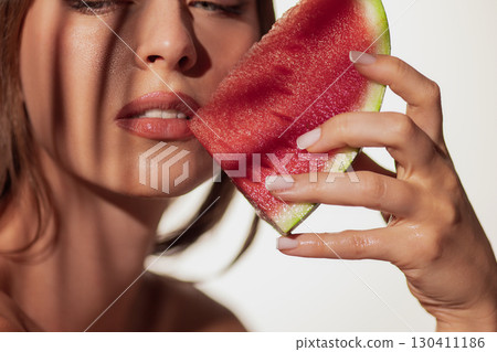 Woman face with watermelon slice against skin freshness Woman face with watermelon slice against skin freshness 130411186