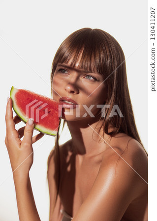 Woman holding watermelon slice with sensual expression Woman holding watermelon slice with sensual expression 130411207