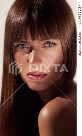 Woman with natural skin and salt crystals on cheek under soft light Woman with natural skin and salt crystals on cheek under soft light 130411237