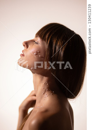 Profile view young woman with crystals of salt on cheek and neck in beauty concept 130411239