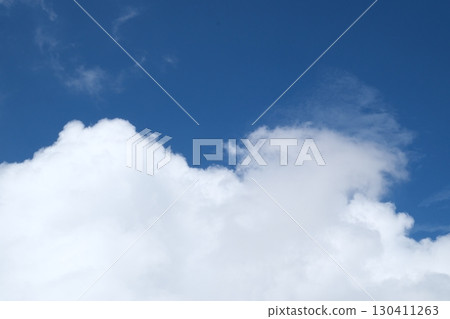 clear blue sky with a few clouds. The sky is very bright and the clouds are scattered throughout 130411263
