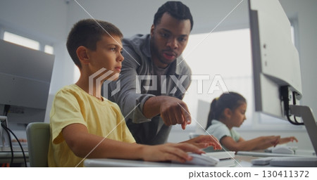 Smart Young Boy Using Computer, Doing 3D Design Project. Teacher Helping Elementary School Student 130411372