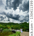 A girl walking on a promenade with a summer blue sky and white clouds 130411399