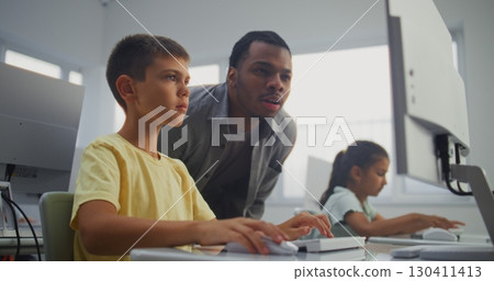 Smart Young Boy Using Computer, Doing 3D Design Project. Teacher Helping Elementary School Student 130411413