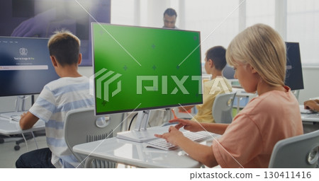 Primary School Girl Working on Creative Project on PC Monitor with Chroma Key During Digital Art Class 130411416