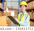 A working Japanese woman checking packaging and inventory at a factory 130411711