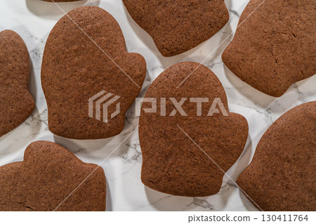 Angled close-up of four Pale Gingerbread Cookies shaped like mittens, highlighting their festive details and rich brown color. Angled close-up of four Pale Gingerbread Cookies shaped like mittens, highlighting their festive details and rich brown color. 130411764