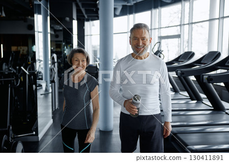 A man and a woman are leisurely walking together in a gym facility 130411891