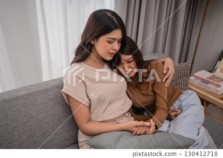 Supportive Friends Offering Comfort and Encouragement to Each Other on a Cozy Sofa Supportive Friends Offering Comfort and Encouragement to Each Other on a Cozy Sofa 130412718