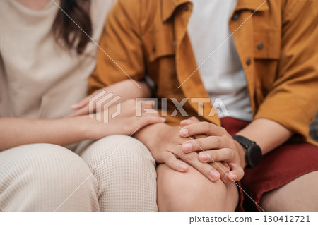 Affectionate Moment A Couple Joyfully Holding Hands in a Cozy, Intimate Setting Affectionate Moment A Couple Joyfully Holding Hands in a Cozy, Intimate Setting 130412721