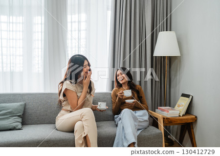 A Group of Joyful Friends Enjoying Tea Together in a Cozy Living Room Setting A Group of Joyful Friends Enjoying Tea Together in a Cozy Living Room Setting 130412729