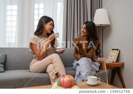 Friends enjoy coffee and joyful conversations in a modern living room 130412748