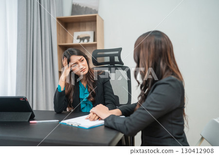 Two Businesswomen Engaged in a Serious Discussion in an Office Setting 130412908