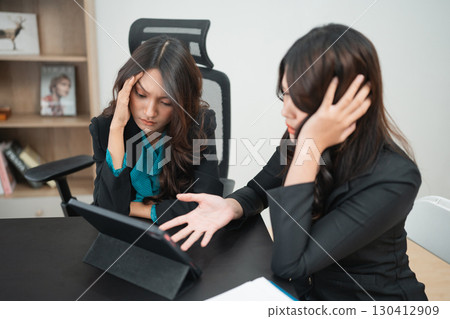 Frustrated Business Partners Analyzing Data on Tablet in Modern Office Frustrated Business Partners Analyzing Data on Tablet in Modern Office 130412909