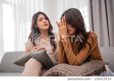 Two Young Women Engaged in an Emotional and Deep Conversation on a Couch Together Two Young Women Engaged in an Emotional and Deep Conversation on a Couch Together 130413014