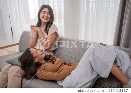 Sharing Joyful Moments of True Friendship Two Women Happily Laughing Together on a Couch 130413187