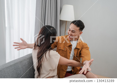 A couple enjoys a playful, lighthearted conversation while cozy at home 130413289
