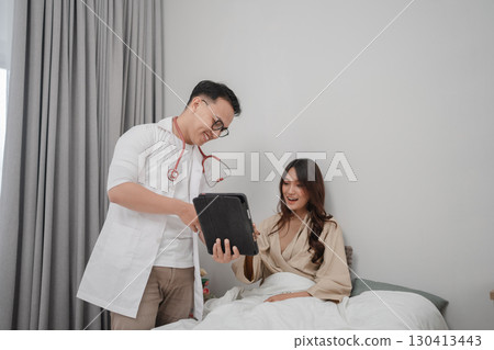 Medical Consultation Doctor Discusses Health with Patient Resting in Bed 130413443